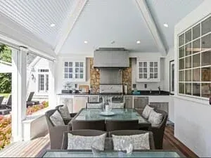 A kitchen under a vaulted white ceiling with glazed gable windows and a long island.