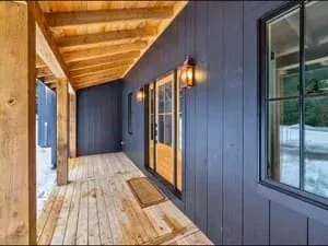 A room with dark blue walls, a warm wood ceiling and a red upholstered chair by the window.